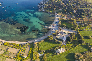 Aerial view of the bay where turquoise waters meet the rugged coastline, a mix of natural beauty and rural charm, Mistra bay, St. Paul's Bay, Malta.