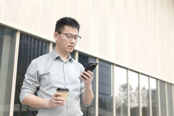 asian businessman using smart phone outdoor