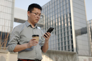 asian businessman using smart phone outdoor