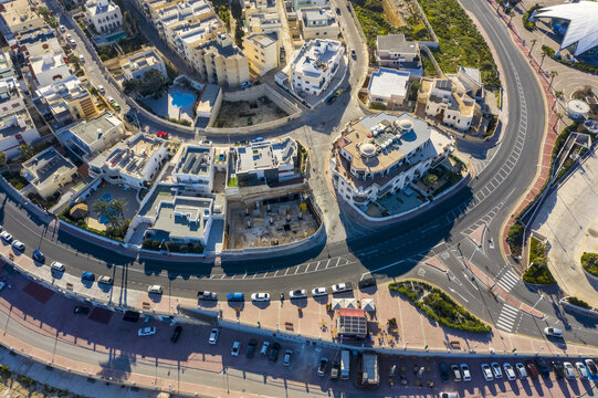 Aerial view of the vibrant Bugibba, where modern architecture meets the azure coast under the clear Maltese sky, Bugibba, St. Paul's Bay, Malta.