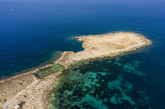Aerial view of the rocky coastline contrasting with the turquoise waters, creating a stunning island landscape, Bugibba, St. Paul's Bay, Malta.