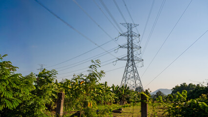 High voltage electricity pylons crossing rural farmland in northern Thailand