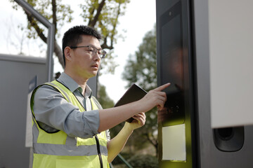 asian Worker uses tablet at charging station