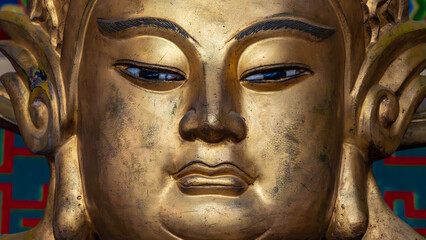 Close up of serene golden Buddha statue face with calm expression