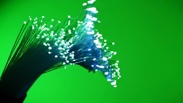 Isolated dynamic bundle of bright glowing green and blue fiber optic cables bending and twisting against a solid chroma key green screen background internet, compositing, blue