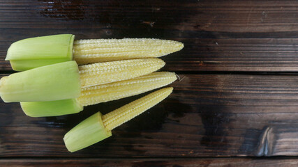 Top view stack of baby corn on wooden table with copy space for text.