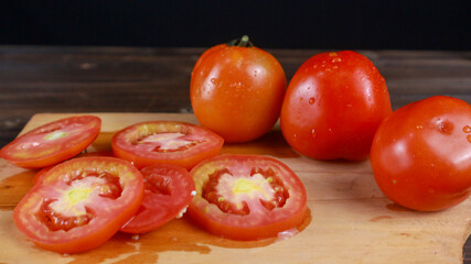 Close up fresh tomatoes on chopping board background, sliced