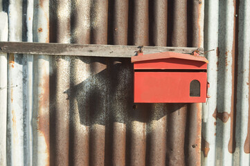 Mailbox on rusty galvanized sheet wall.