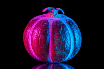 Textured pomegranate fruit with pink and blue neon split lighting on black background