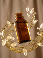 Amber glass bottle with golden liquid and crystals in swirling motion