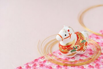 Decorative horse figurine on pink fabric isolated on white background