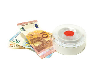 V16 roadside emergency light next to 80 Euro banknotes. Concept of traffic fines or mandatory vehicle safety equipment in Spain.