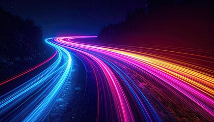 Long exposure shot of car light trails curving along an open road beneath a starlit night