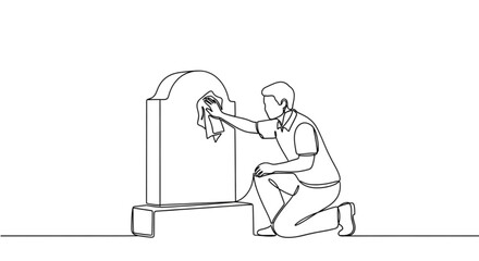 Man cleaning gravestone while kneeling in a cemetery  