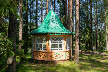 Wooden enclosed gazebo in the forest on a summer day