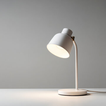White desk lamp casting warm light on minimalist table with soft shadow and neutral background