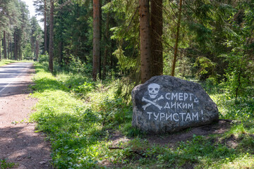 TETKOVO, Tver region, RUSSIA. The inscription on the stone near the highway is Death to wild tourists