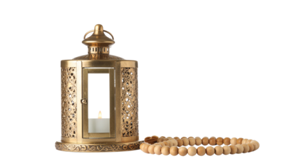 Gold colored decorative lantern with a small object lying next to it in a studio shot, isolated plain white background and png