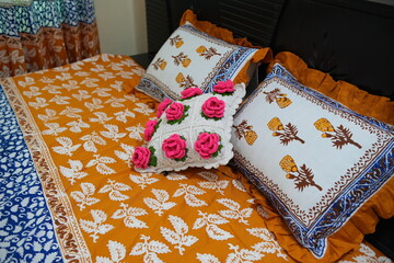 Vibrant Home Decor with Orange Leaf Print Bedspread and Floral Cushions