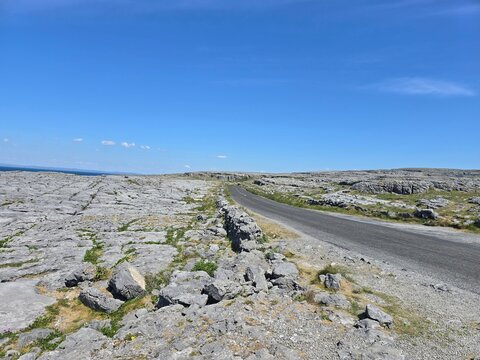 Winding road through the ancient limestone karst landscape of The Burren in County Clare, Ireland