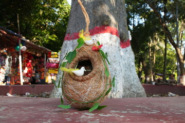 Handcrafted Bird's Nest Decoration with Artificial Birds by a Sacred Tree