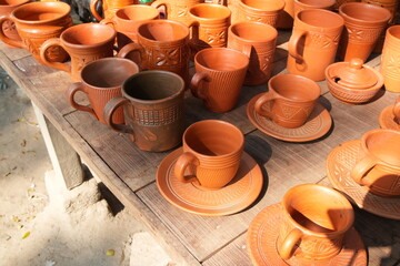 Collection of Handmade Terracotta Pottery Mugs and Cups on a Wooden Table