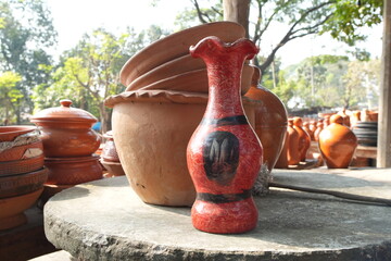 Vibrant Red Pottery Vase on Display at an Outdoor Market