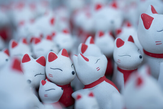 Ceramic Kitsune fox dolls lined up: Symbol of a Japanese shrine