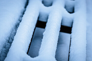 Close-up view of snow-covered wooden slats, showcasing intricate textures and patterns, with a serene winter atmosphere, highlighting the beauty of nature's frost