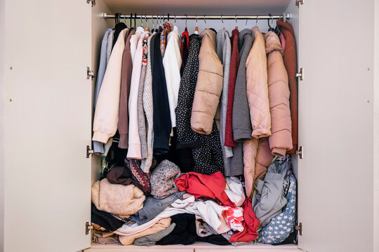 Mess in Closet. Closet clutter. Chaos with Clothes. Wardrobe mess. Mess on Hanger rack.  Sort Clothes. Disorder and Decluttering of wardrobe.