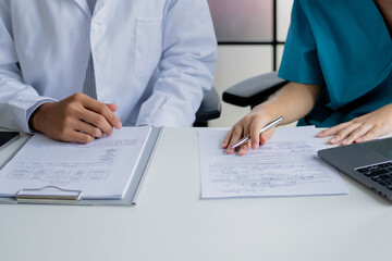 Doctor and nurse consulting on patient medical record in hospital