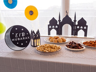Eid Mubarak table with Ramadan sweets, dates, nuts and festive decor