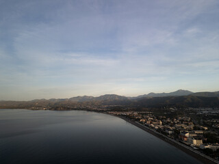 Aerial panoramic shot of foggy mountain valley during morning golden hour.