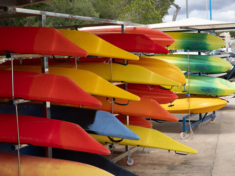 Porta Petro Mallorca, Spain January 01 2026 racks of hire canoes and kayaks multi colored on the marina