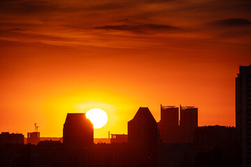 Obraz premium Huge sun setting behind Kyiv apartment buildings