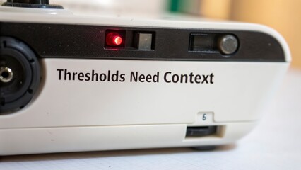Device with Red Alarm Light and Text 'Thresholds Need Context'