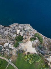 Dramatic coastline with steep cliffs and crashing waves at sunset aerial
