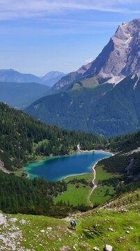 Vertical aerial drone view of the Alps mountains, with Coburger H&uuml;tte located near the scenic lakes Seebensee and Drachensee on a bright, sunny summer day. People are enjoying a beautiful view.