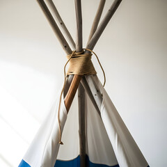 A traditional native american teepee structure with white and blue fabric