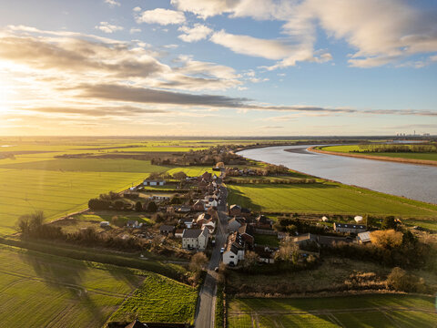 Aerial view of the village of Whitgift in East Riding of Yorkshire, England, surrounded by farmland and countryside near the River Ouse under evening light.
