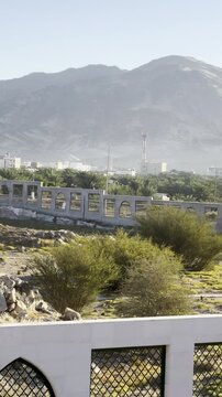 Scenic mountain landscape near the historic Shuhada Badr area, overlooking Madinah with rocky hills, green terrain, and distant city buildings, reflecting the natural and historical surroundings.