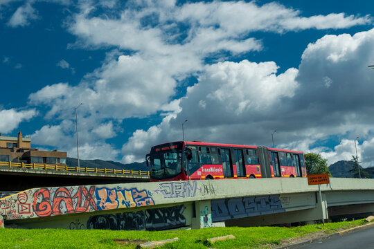 Bogot&aacute;, Colombia. January 21, 2025. A red Transmilenio articulated bus travels down a Bogot&aacute; Street.