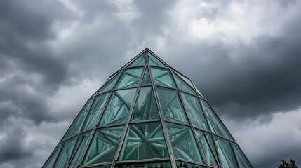 Dramatic Pyramid Structure with Reflective Glass Facade Against Moody Sky