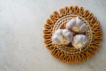 Fresh garlic bulbs resting on woven trivet