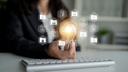 A business professional presents a light bulb symbolizing innovation, surrounded by cloud technology icons in a modern workspace, illustrating digital transformation concepts. Gantry