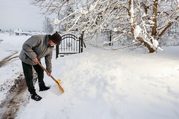 Man removing snow from the sidewalk after snowstorm.