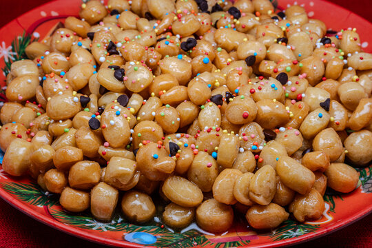 Struffoli are a typical dessert of the Neapolitan Christmas tradition, made up of small balls of sweet dough, fried and then covered in honey and colorful decorations.