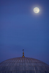Full moon glowing in a purple evening sky above a botanical mosque dome. Spirituality and sustainability concept for wallpaper or template focused on green herbal alternative medicine peace.