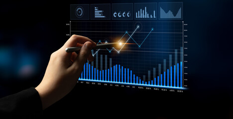 A business analyst engages with a digital screen to analyze financial trends and data. The modern...