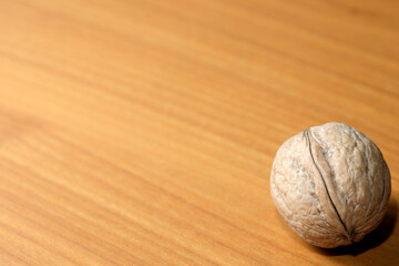 Round walnut resting on a smooth wooden surface under soft light